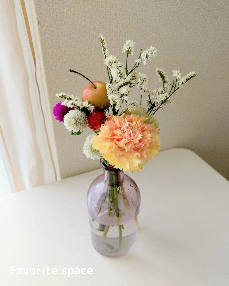 セリアのグラデーションピンクの花瓶にカーネーションなどを飾った画像