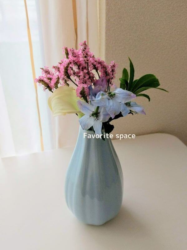 ダイソーの青色の花瓶に花をブルーミーの飾った画像