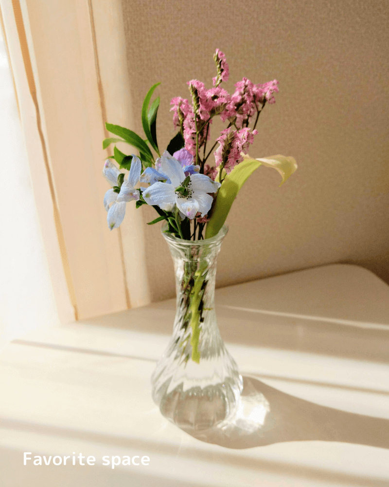 セリアのガラスの花瓶にカラーなどの花を飾った画像